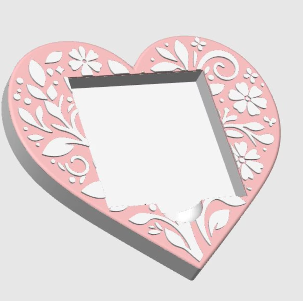 Heart-shaped sticky note pad holderwith floral designs on a light gray background