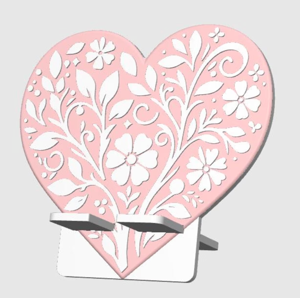 Heart-shaped decorative item with floral patterns on a stand against a light gray background