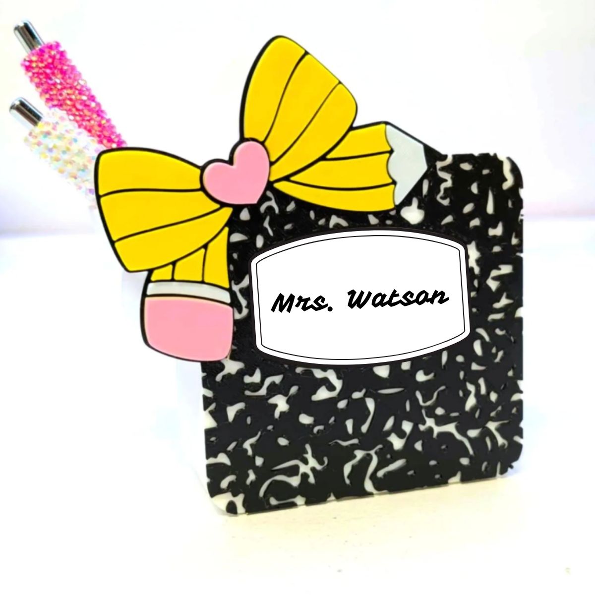 Pencil-shaped container with a yellow bow and pink heart, labeled 'Mrs. Watson', on a white background.