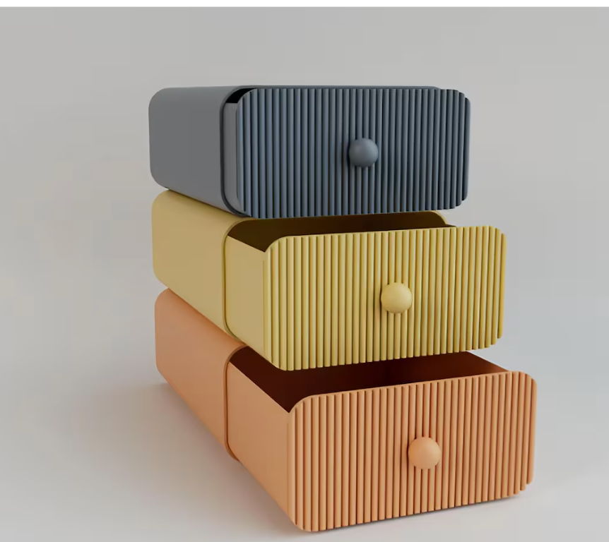 Stack of three ribbed storage drawers in gray, beige, and brown on a light background