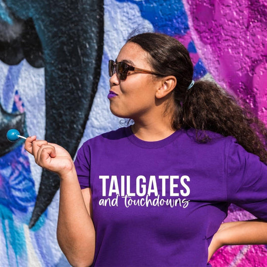 Featuring African American woman with purple graphic t-shirt, tailgates and touchdowns printed on the front.